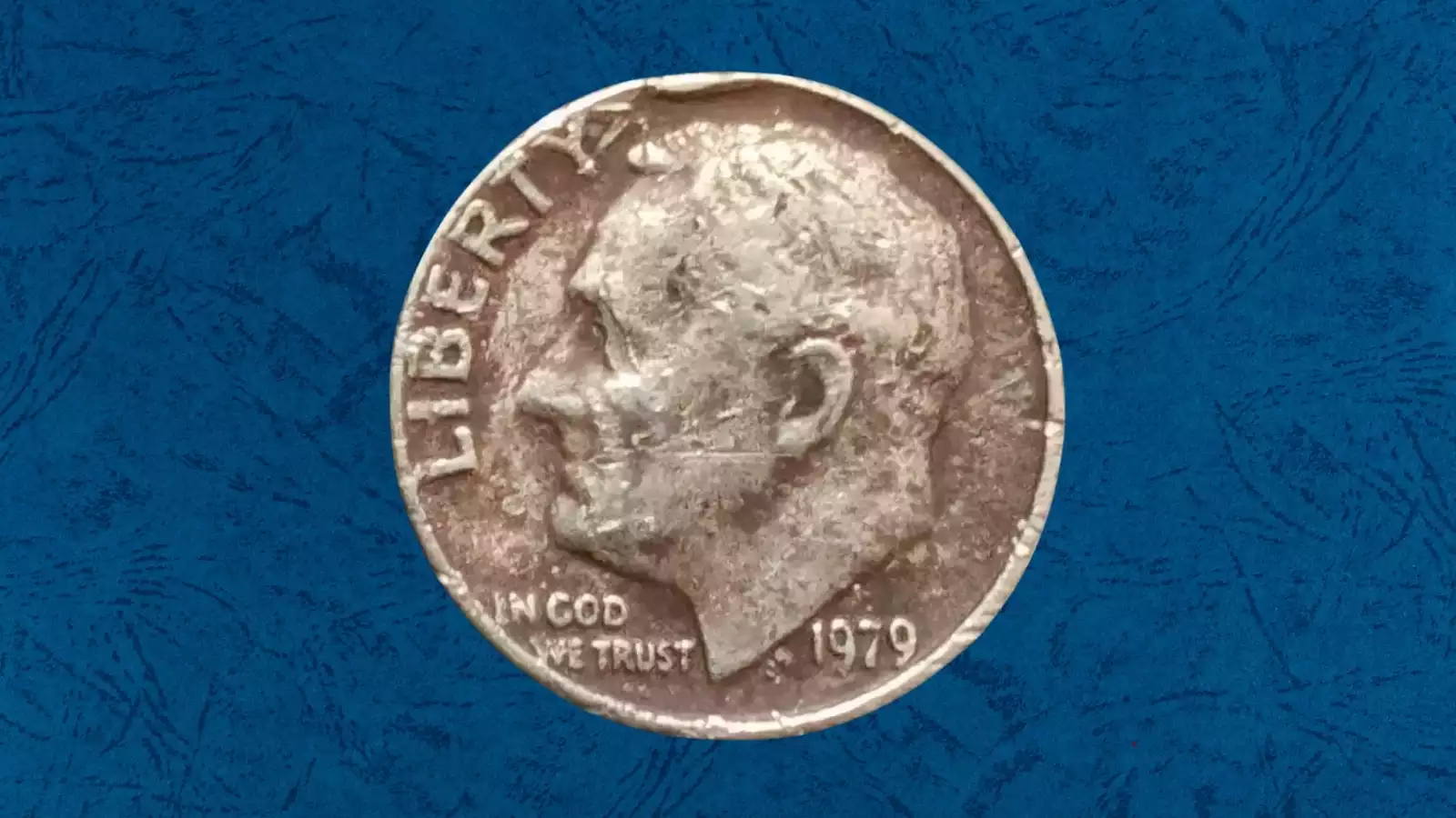 1979 Roosevelt dime missing clad layer error showing reddish-brown copper core exposed on the obverse face